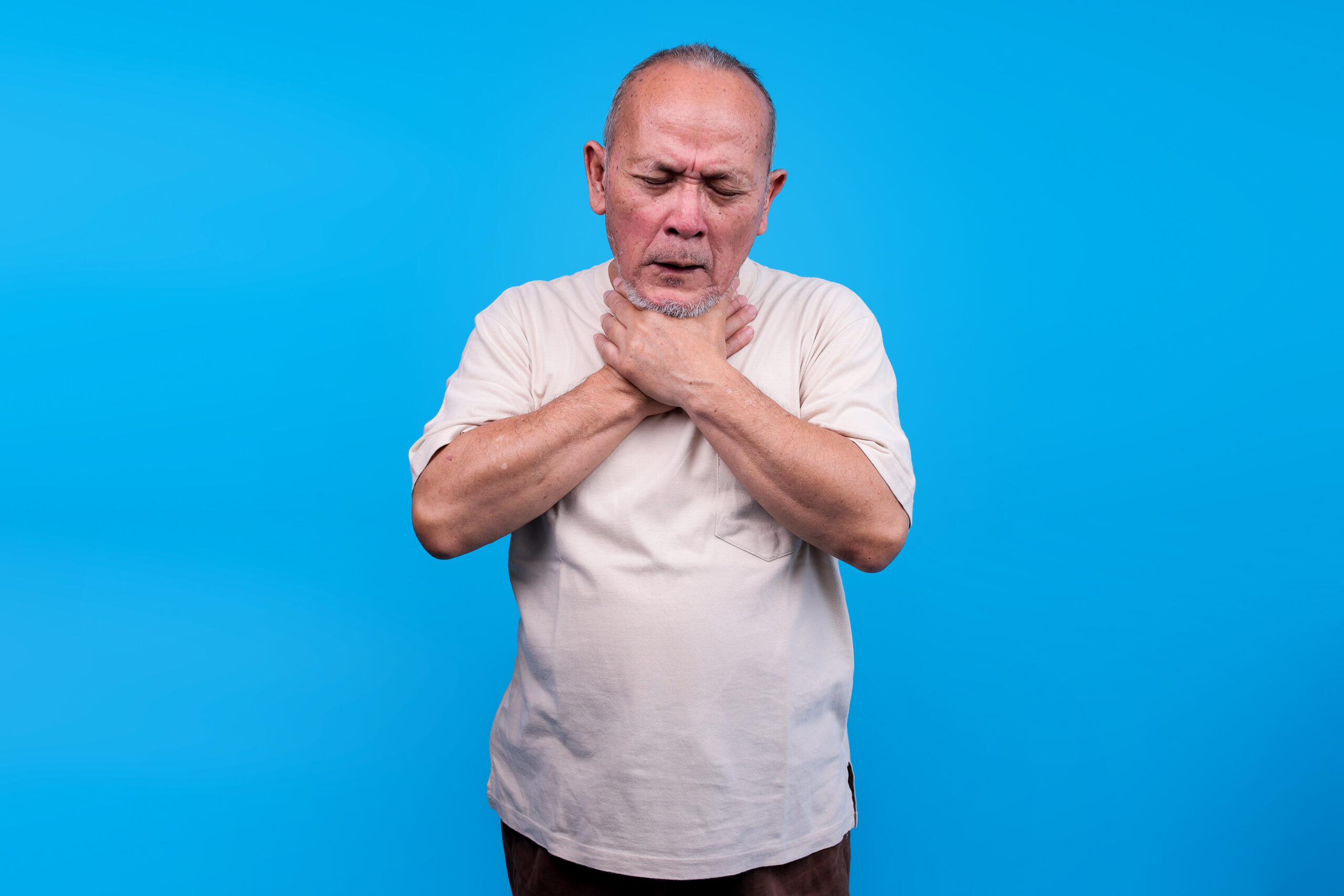 Mature Asian Man Clutching His Throat With Both Hands Possibly Choking Or Experiencing Severe Throat Pain Choking