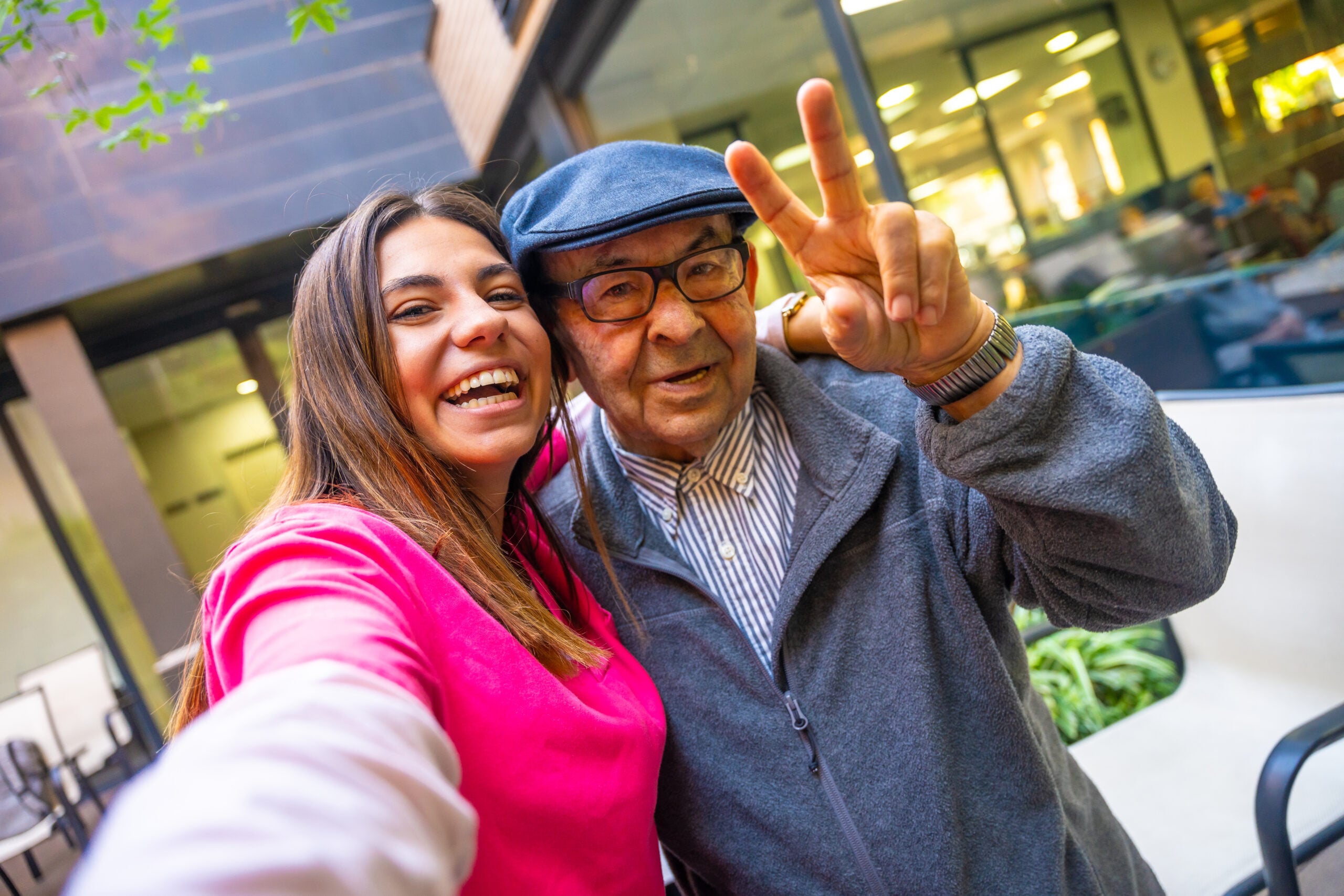 Granddaughter, a nurse, caring for the elderly, a girl (woman) and grandfather, do selfie, happy, smiles, in the park. Concept boarding house, sanatorium, house for the elderly, help for the elderly