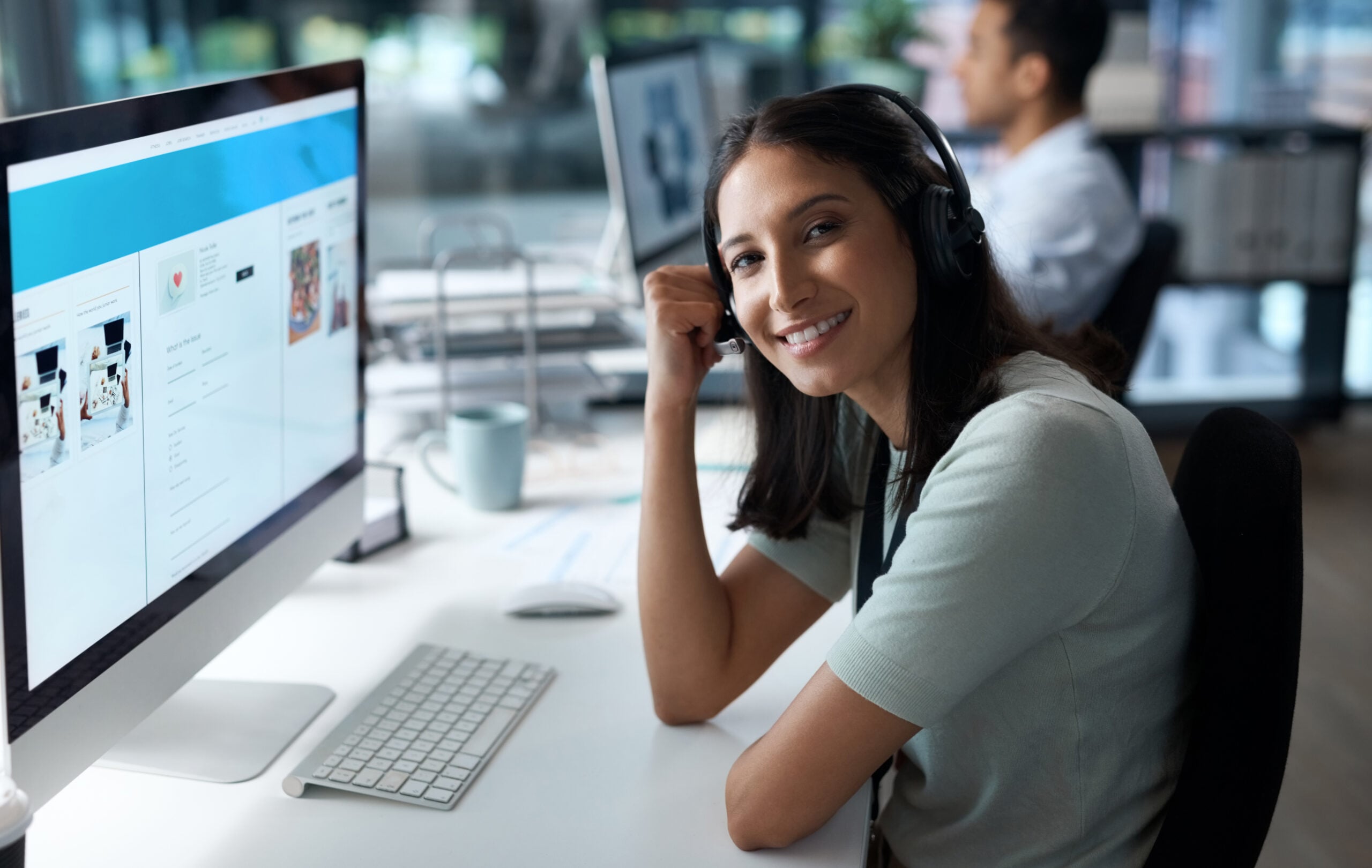 I never miss a call. Portrait of a young woman using a headset and computer in a modern office