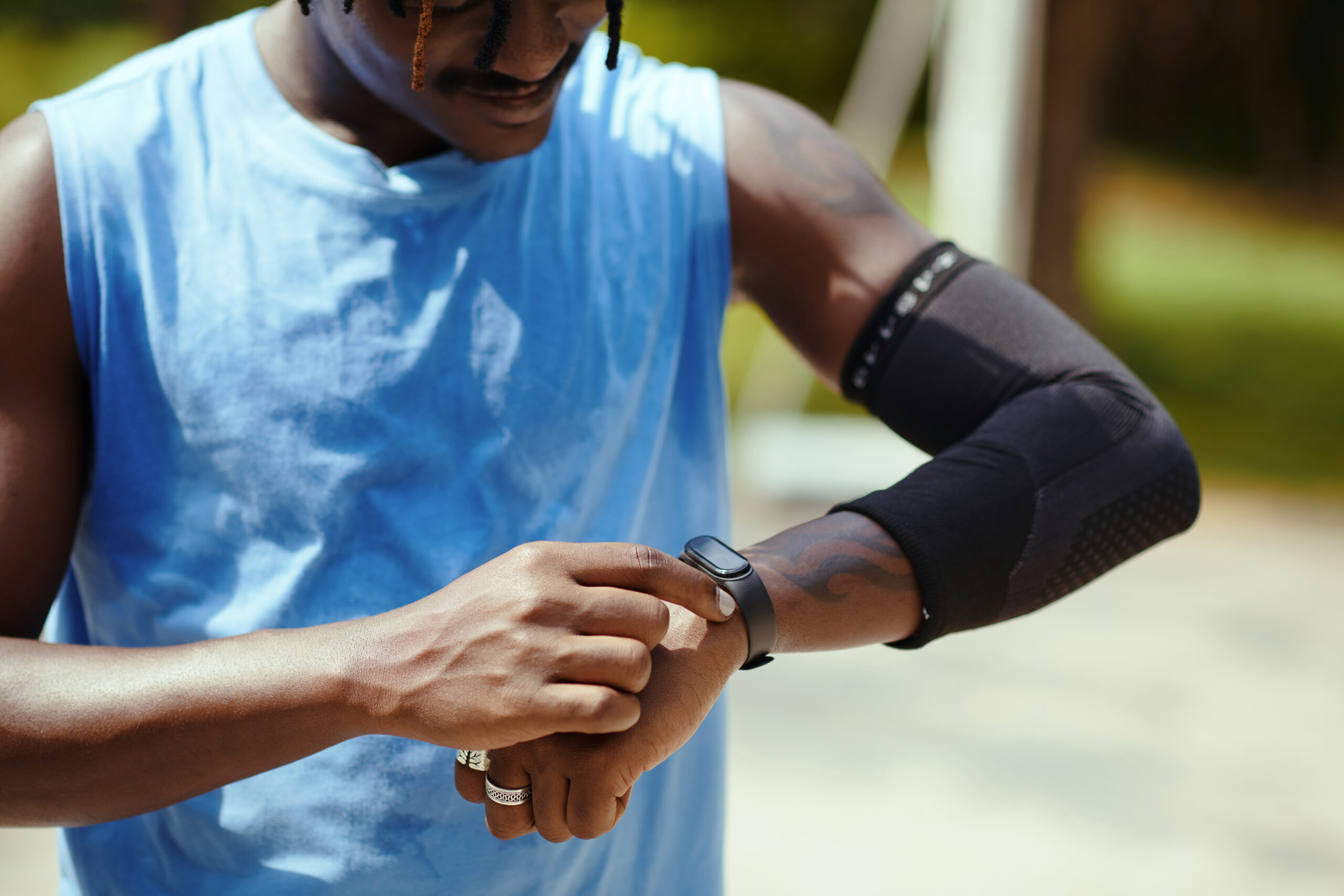 Streetball player checking fitness tracker after outdoor training