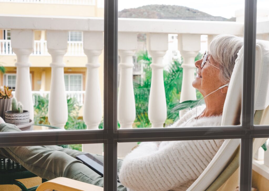 A senior woman relaxing at home on a balcony