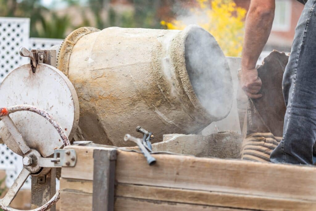 Construciton Worker Mixing Cement At Construction Site.