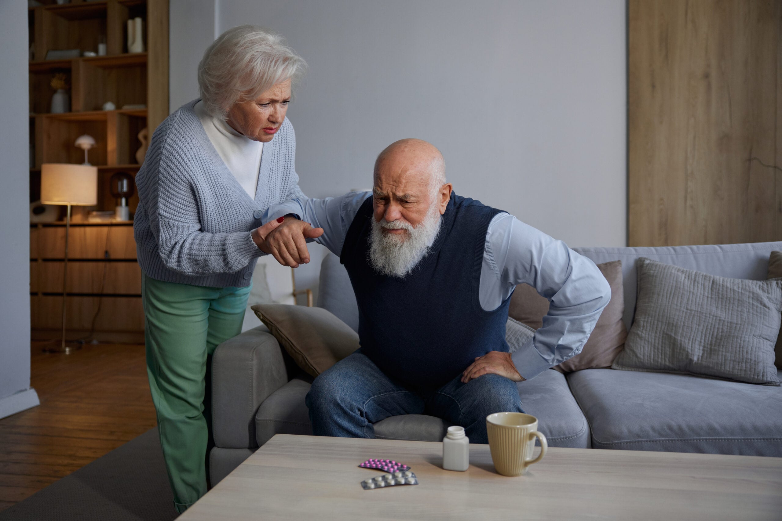 Elderly wife feeling worried due to cramp symptom of her senior husband