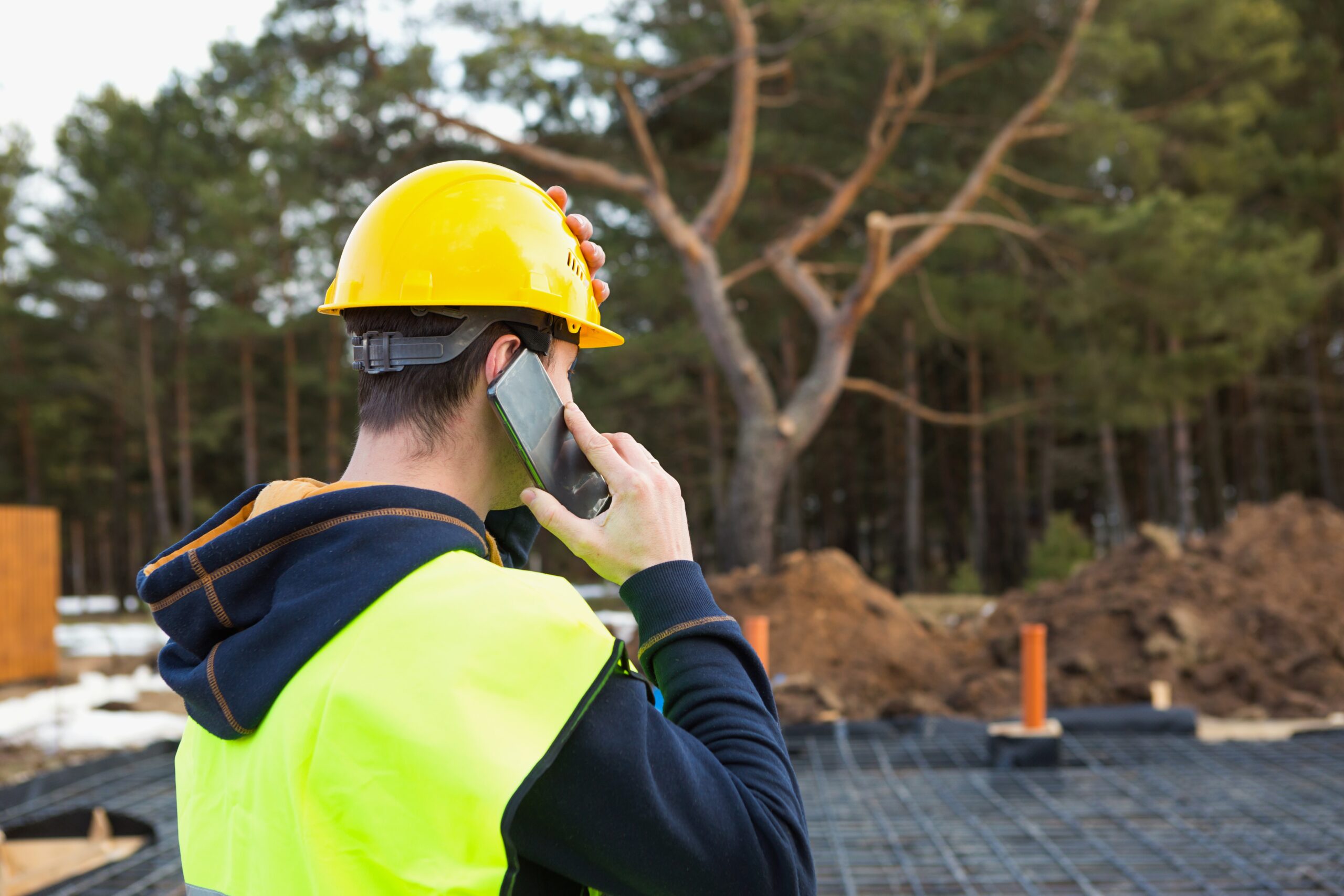 construction-worker-talks-on-a-smartphone-in-a-yellow