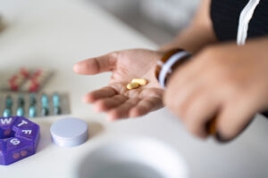 Sick illness woman hold two pill on hand pouring capsules from medication bottle take painkiller supplement medicine. Healthcare, headache, treatment, therapy concept. beta blockers
