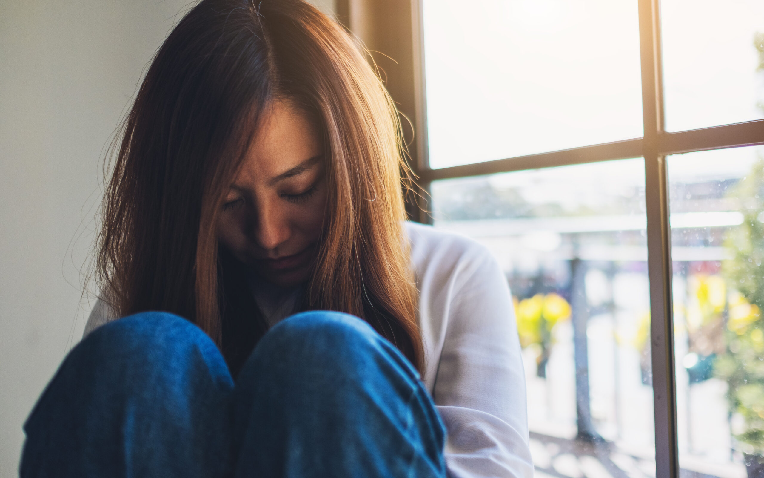 woman-with-long-hair-sitting-near-a-window