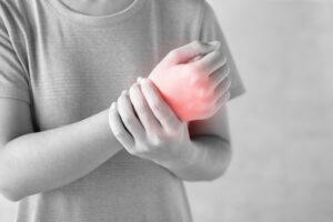 Young woman holding her wrist pain because using computer long time. De Quervain's tenosynovitis, Intersection Symptom, Carpal Tunnel Syndrome or Office syndrome.Disease and healthcare concept national pain week
