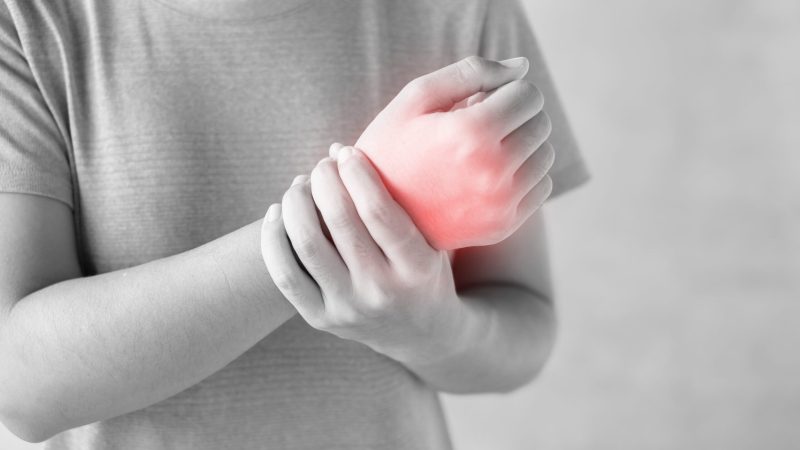 Young woman holding her wrist pain because using computer long time. De Quervain's tenosynovitis, Intersection Symptom, Carpal Tunnel Syndrome or Office syndrome.Disease and healthcare concept national pain week