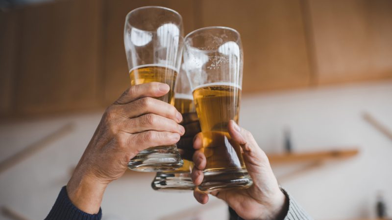 cropped shot of friends clinking glasses international beer day
