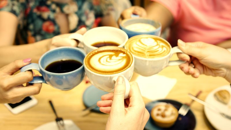 Friends having coffee at a cafe international coffee day