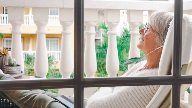 A senior woman relaxing at home on a balcony