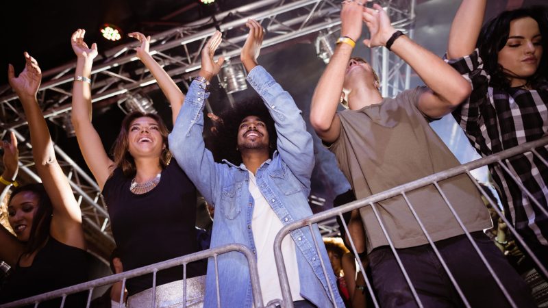Low angle view of crowd enjoying at nightclub during music festival crowd management
