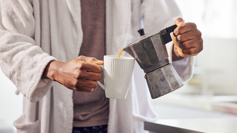Shot of an unrecognizable man pouring coffee into a cup at home. coffee making